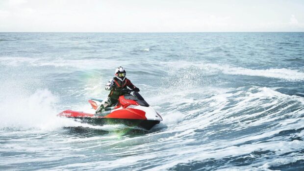 A person rides a red and white jet ski rapidly through ocean waves in this jet ski wallpapers, HD Desktop Wallpaper
