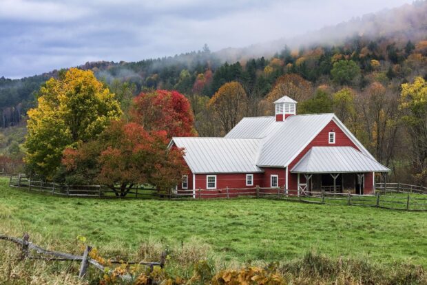 A red barn stands in a green field with colorful autumn trees and misty hills in the background featuring Vermont Wallpapers, HD Desktop Wallpaper