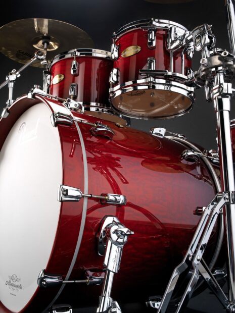 A red drum set with shiny chrome hardware and cymbals on a dark background, 2K Mobile Wallpaper