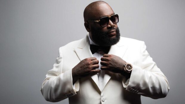 Rick Ross in a white suit adjusting his jacket with sunglasses and a watch, HD Desktop Wallpaper