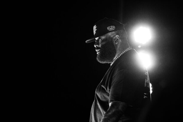 Rick Ross is performing on stage with bright lights behind him, HD Desktop Wallpaper