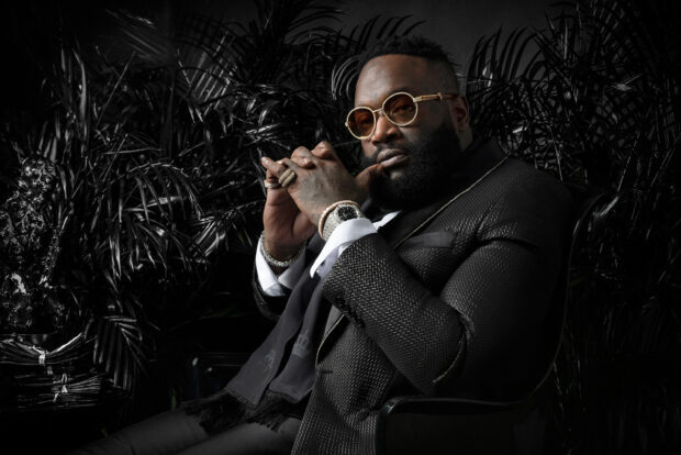 A confident man wearing a textured suit and gold sunglasses sitting thoughtfully, HD Desktop Wallpaper
