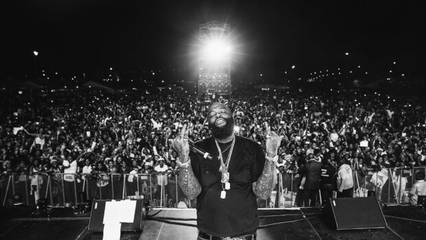 Rick Ross is performing live on stage in front of a large crowd at night, HD Desktop Wallpaper