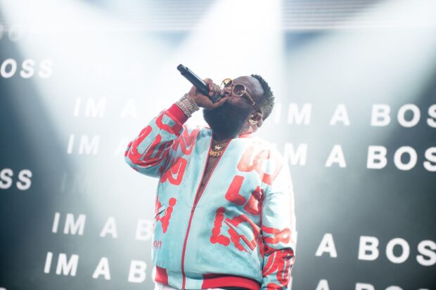 Rick Ross is singing into a microphone during a concert with bright stage lights, HD Desktop Wallpaper