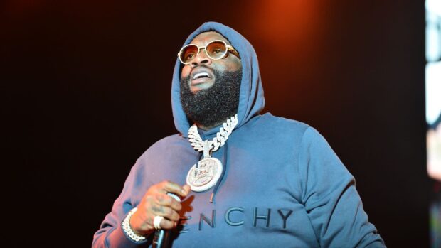 Rick Ross is performing on stage wearing a hoodie and large jewelry, HD Desktop Wallpaper