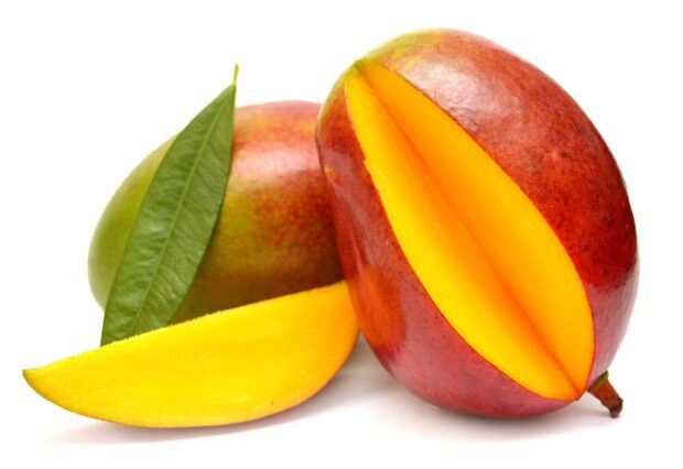A ripe mango with a slice and fresh green leaves showcases vibrant mango wallpapers, 2K Desktop Wallpaper