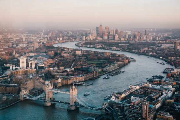 A panoramic view of the River Thames winding through London with iconic buildings and bridges, Desktop Wallpaper