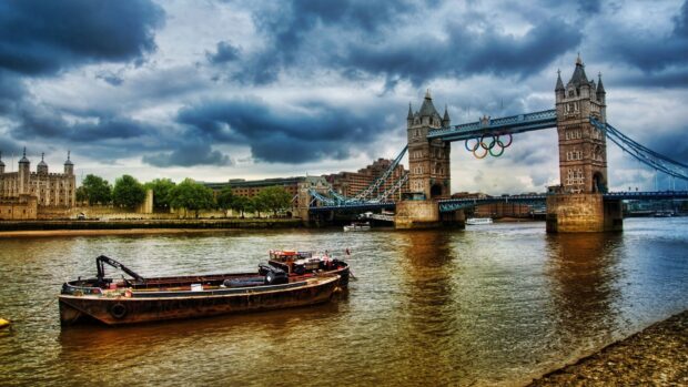 The River Thames showcases Tower Bridge under a cloudy sky with boats on the river, HD Desktop Wallpaper