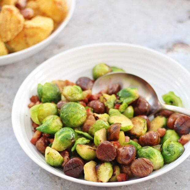 Roasted chestnuts mixed with Brussels sprouts and bacon in a white bowl, HD Desktop Wallpaper