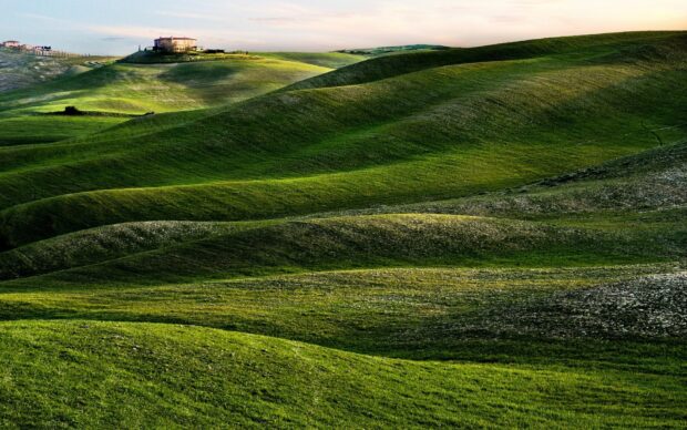 Green hills stretch gently under a cloudy sky with a house on the hill, HD Desktop Wallpaper