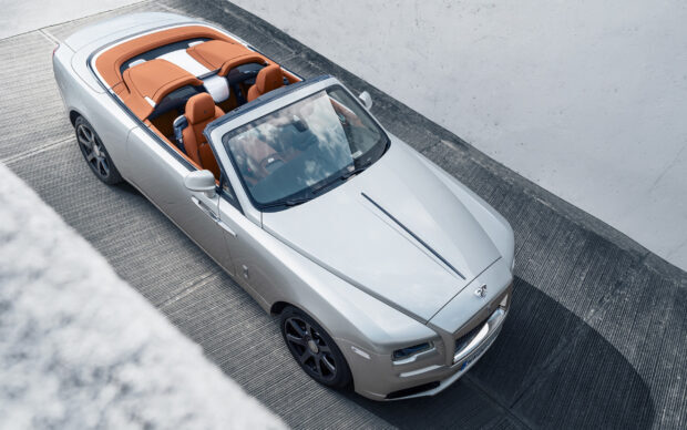 A luxury Rolls Royce Dawn convertible car parked on a modern concrete driveway, 2K Desktop Wallpaper