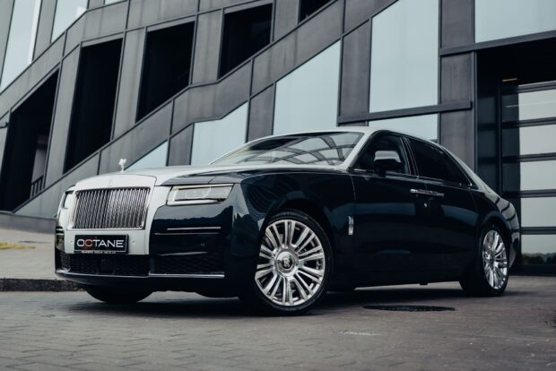 A Rolls Royce Ghost is parked near a modern glass building under an overcast sky, HD Desktop Wallpaper