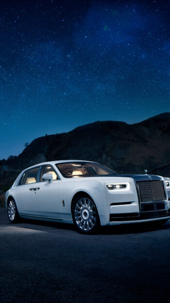 A white Rolls Royce Ghost parked on a dark road with a clear star filled sky, 4K Phone Wallpaper