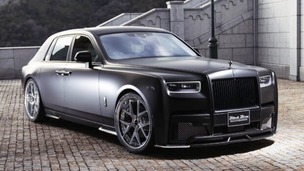 A black Rolls Royce Phantom with sleek wheels parked on a cobblestone street, 2K Desktop Wallpaper