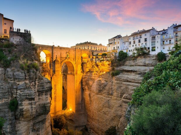 The illuminated Ronda bridge spans the deep gorge under a colorful sunset sky, Spain Wallpapers, HD Desktop Wallpaper