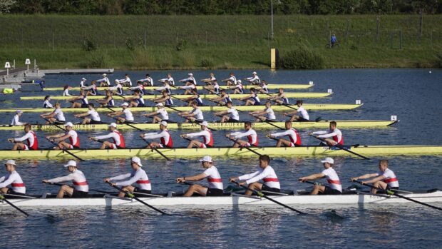 Rowing teams competing in a race on calm water with synchronized rowing motion