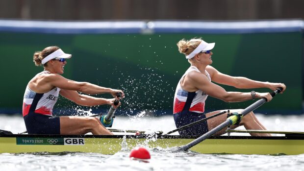Two athletes rowing together in a competitive rowing race showing strong teamwork and concentration