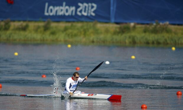 Athlete rowing a kayak in a competitive race on calm water at London 2012 event