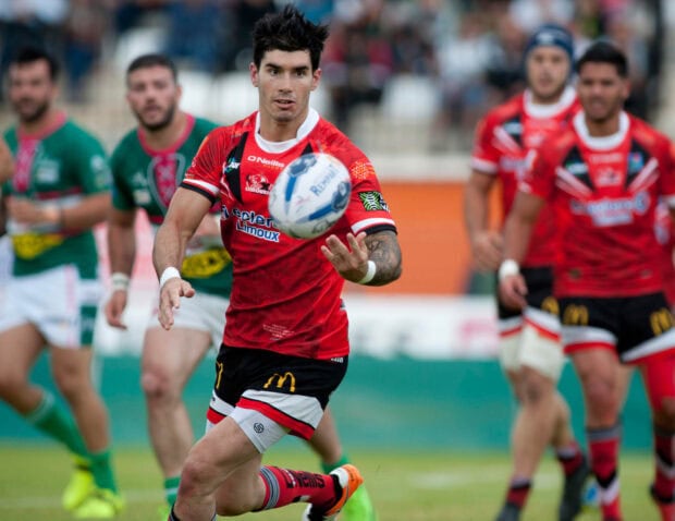 A rugby league player in red jersey is passing the ball during a match, HD Desktop Wallpaper