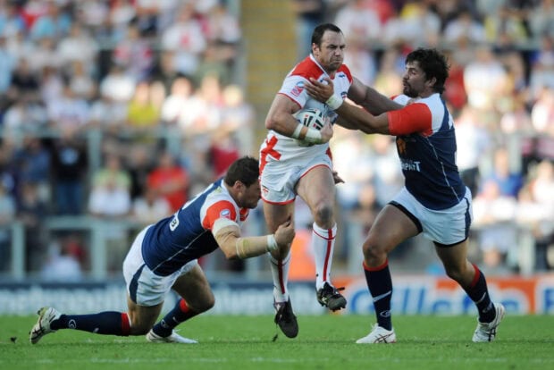 A rugby league player is tackling an opponent holding the ball during a competitive game, 2K Desktop Wallpaper