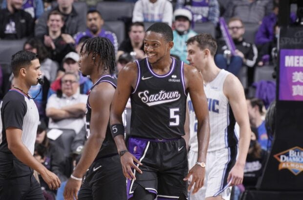 Sacramento Kings players are smiling and interacting during a basketball game in this high quality wallpaper