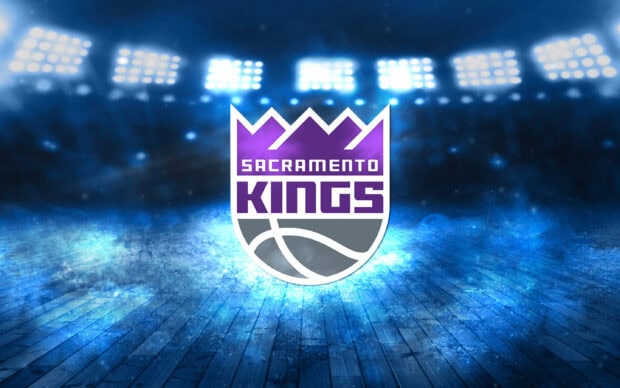 Sacramento Kings logo displayed on a glowing blue basketball court under bright stadium lights