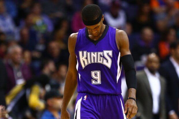 Sacramento Kings player wearing purple uniform with number 9 standing on the court looking down