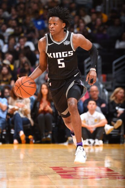 A Sacramento Kings player wearing jersey number 5 dribbling the basketball on the court during a game