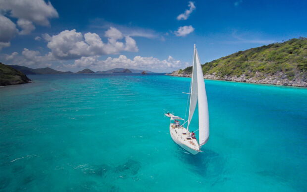 A sailboat is sailing blue waters near Dominica Island under a clear sky, HD Desktop Wallpaper