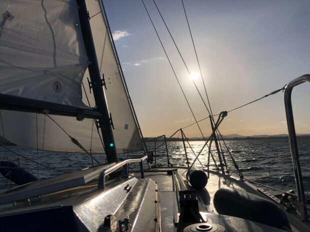 The view from the deck of a sailing boat with sails raised on a sunny day