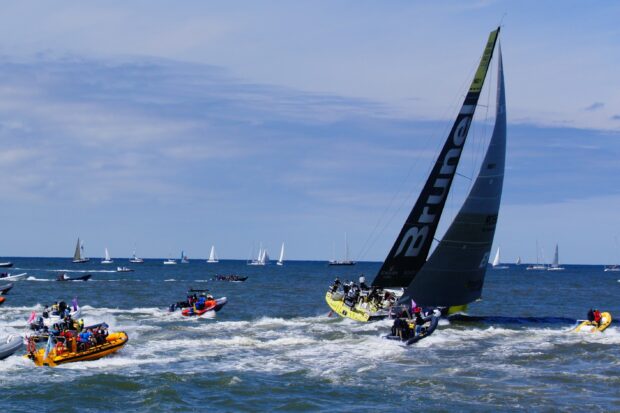 A sailing boat with crew navigating the sea during a sailing race