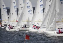 Sailboats racing on water with crews navigating in a sailing competition
