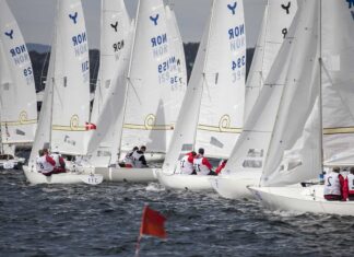Sailboats racing on water with crews navigating in a sailing competition