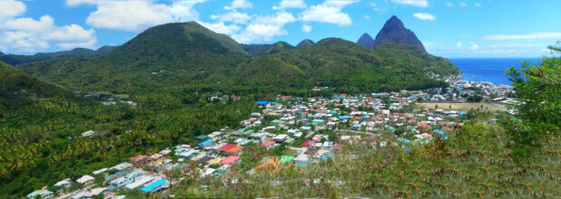 A panoramic view of Saint Lucia town nestled among lush green hills and coastal landscape
