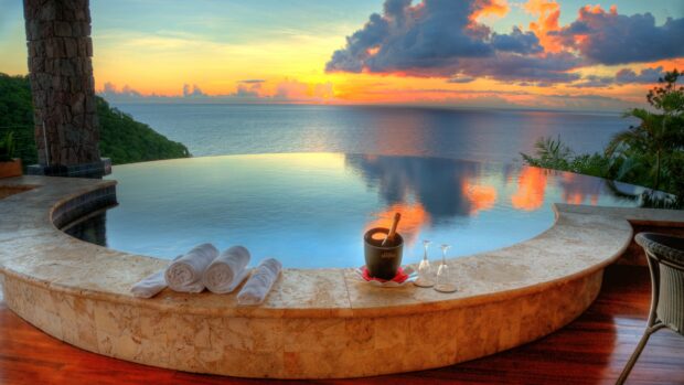 A serene Saint Lucia view with an infinity pool overlooking the ocean at sunset