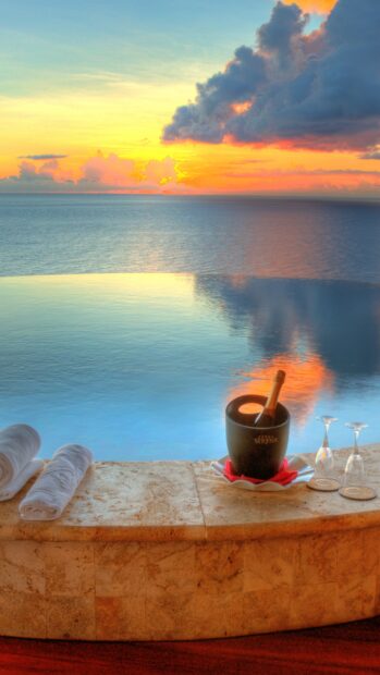 Sunset over Saint Lucia with champagne and towels by infinity pool