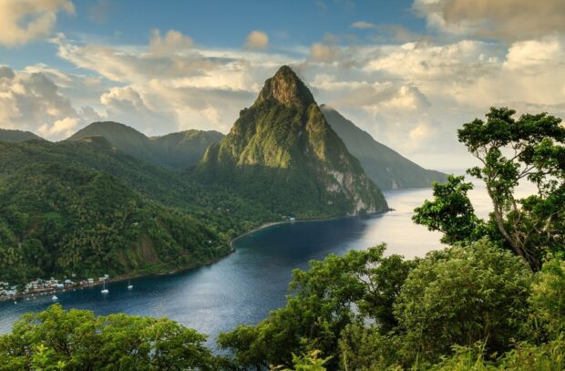Lush green hills of Saint Lucia surrounded by calm blue sea and cloudy sky