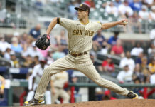 A San Diego Padres player throws a pitch during a baseball game in front of a crowded stadium, 2K Desktop Wallpaper