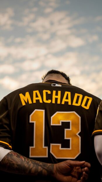 A San Diego Padres player wears a Machado jersey with number 13 under a cloudy sky, HD Phone Wallpaper