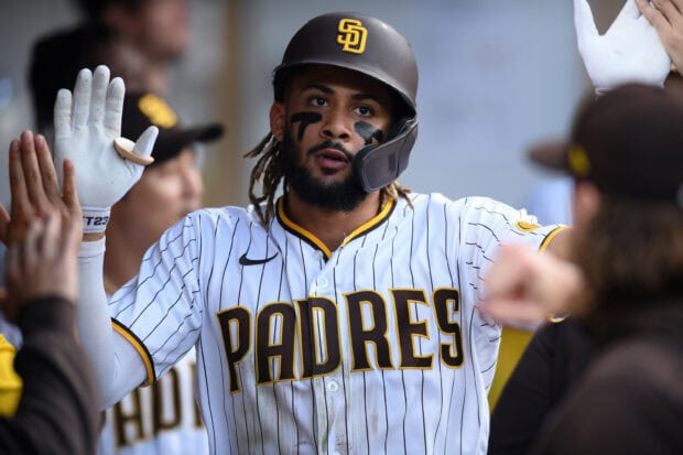 A San Diego Padres player gives high fives to teammates in the dugout during a game, 2K Desktop Wallpaper