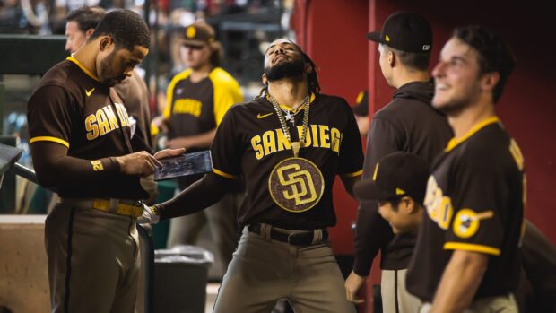A San Diego Padres player wears a large pendant while teammates gather in the dugout, 2K Desktop Wallpaper