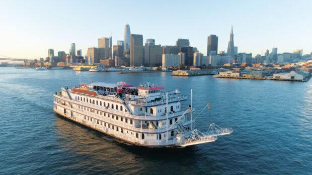A historic San Francisco skyline boat sailing in the water with city buildings in the background