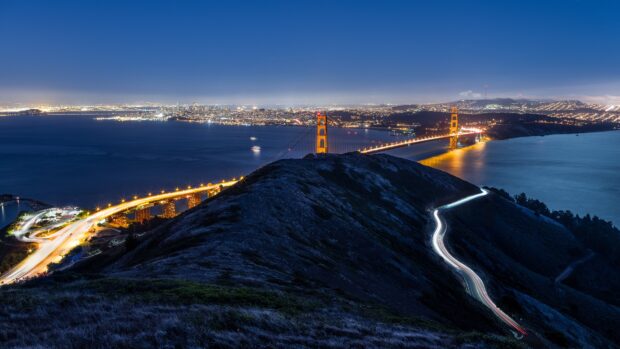 San Francisco skyline viewed from a hill with the Golden Gate Bridge and city lights at night
