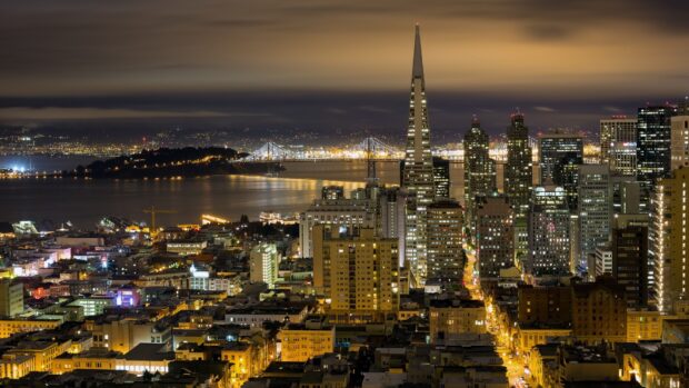 San Francisco skyline at night with illuminated buildings and the Bay Bridge in view