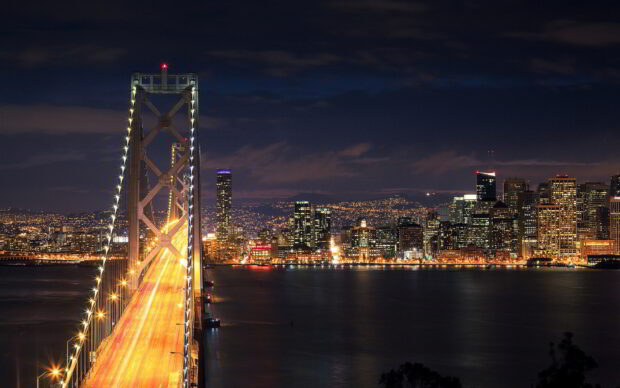 Night view of San Francisco skyline with illuminated bridge and city lights