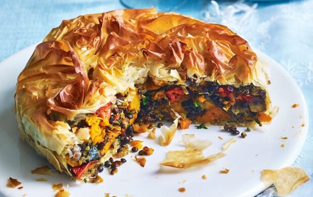 A freshly baked savory pie filled with lentils and vegetables on a white plate, 2K Desktop Wallpaper