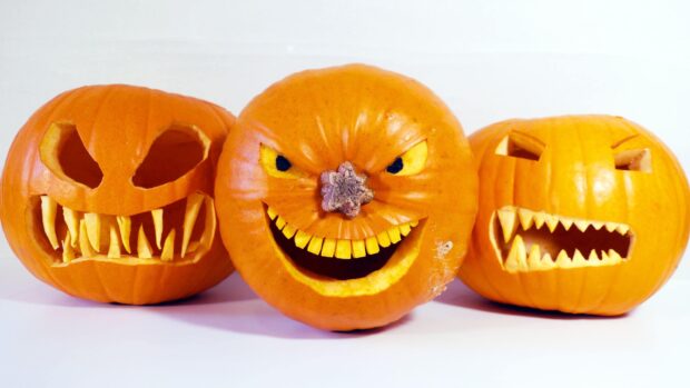 Three Halloween pumpkins have scary carved faces and glowing eyes, 2K Desktop Wallpaper