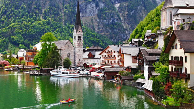 A scenic town with a church tower beside a lake and boats in Austria, 4K Desktop Wallpaper