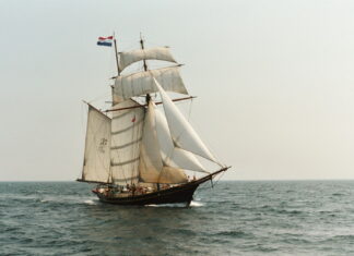 Classic schooner sailing on the open sea with full white sails and Dutch flag