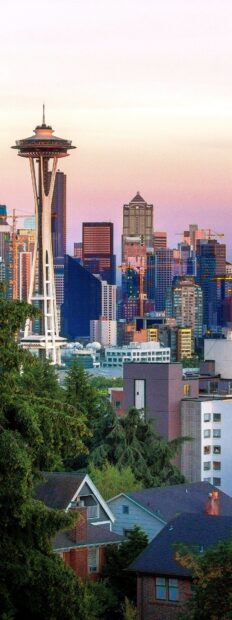 The Seattle skyline at dusk features the Space Needle surrounded by modern buildings and greenery, 4K Mobile Wallpaper